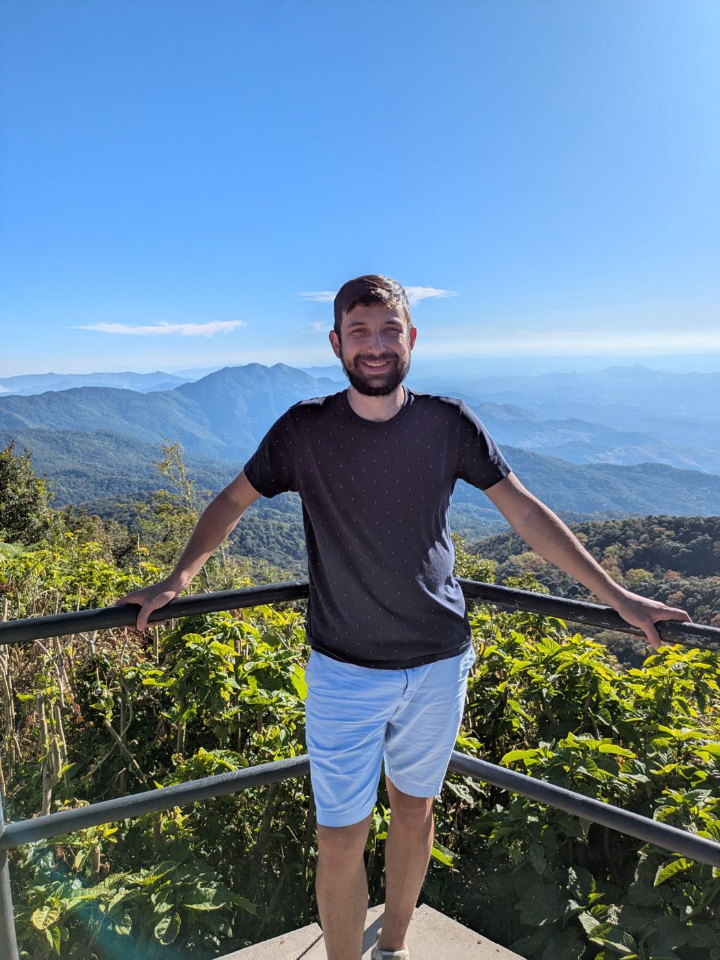 Liam at a mountain viewpoint on Doi Inthanon with ridges stretching to the horizon
