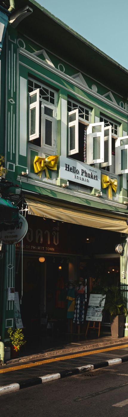 A green Sino-Portuguese shophouse with white shutters in Phuket Old Town